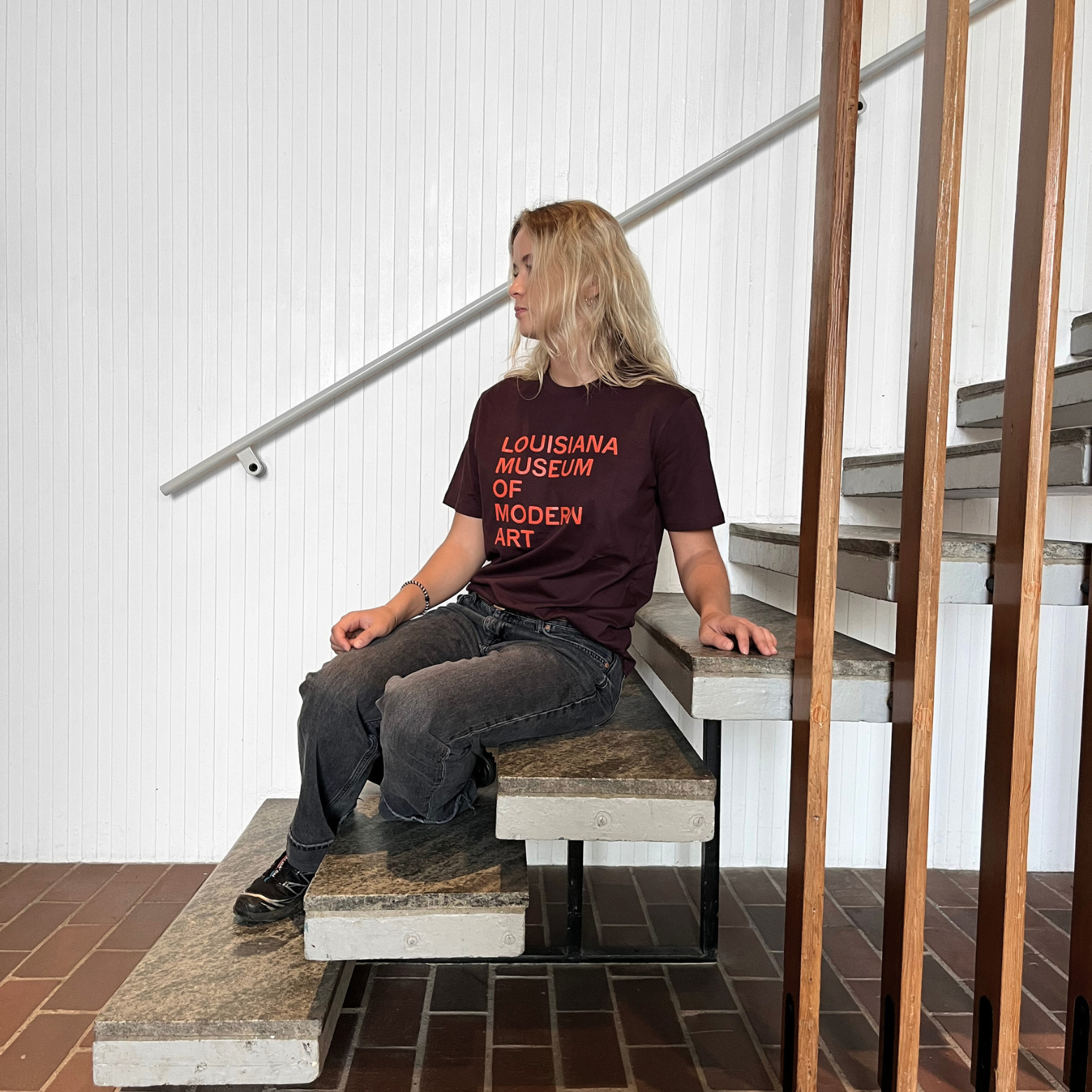 Louisiana T-shirt i brun med teksten “Louisiana Museum of Modern Art” i orange print på Louisiana Museum of Modern Art.