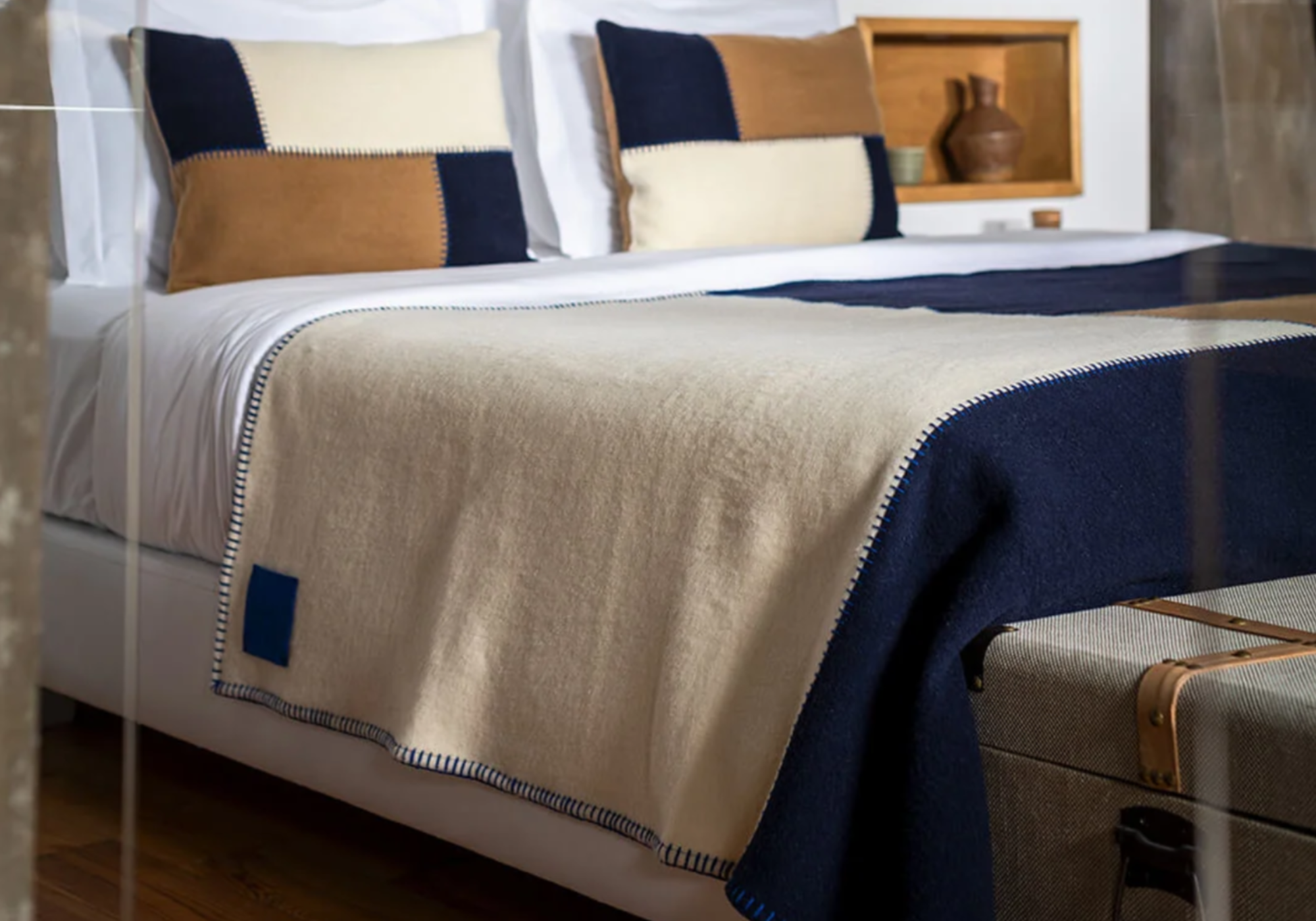 Burel Factory sengetæppe og pude med patchwork i camel / pearl / navy på seng med puder