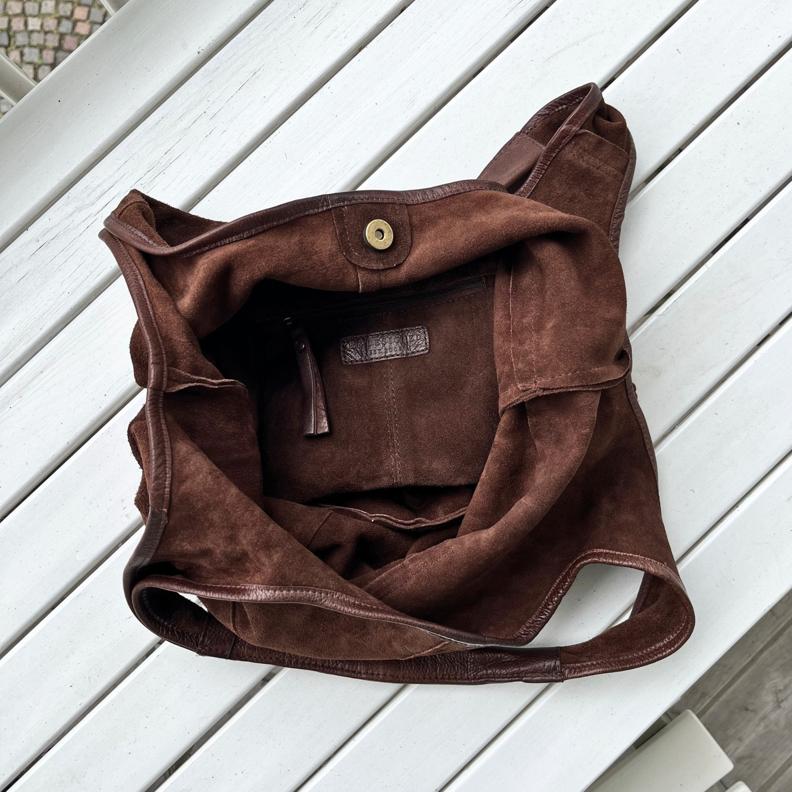 Lyra suede totebag fra Re:designed ligger åbent på bord ved Louisiana Museum of Modern Artligger 