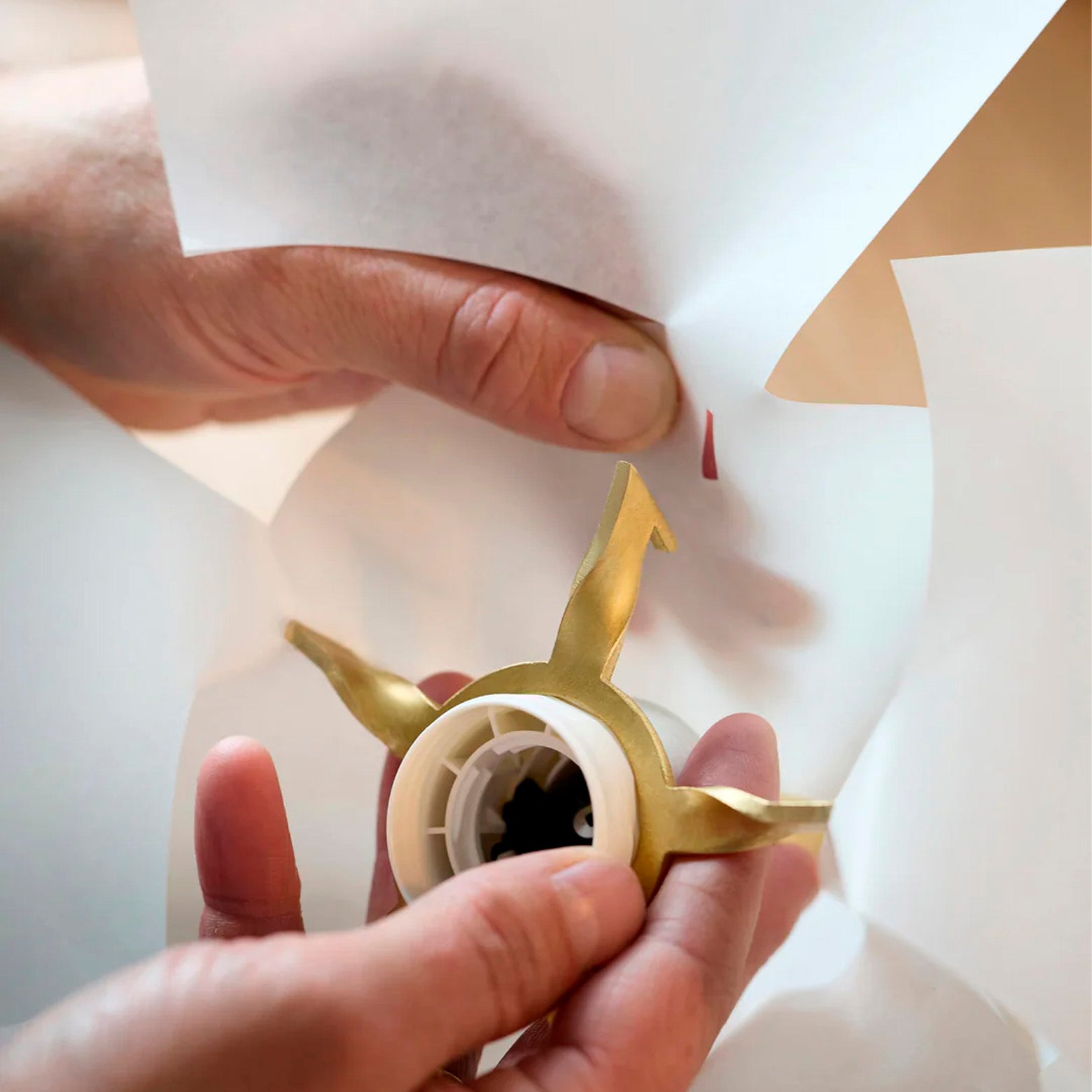 Pendellampe i lagdelt japansk papir med skulpturel, organisk form monteret på et stjerneformet beslag i messing stylet i hånden. Moebe.