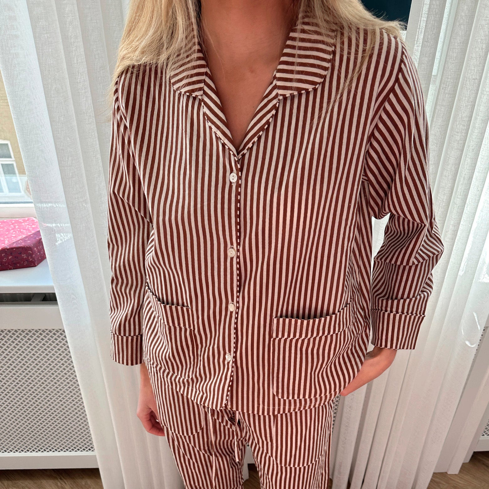 Pyjamassæt i økologisk bomuld med hvide og brune striber stylet på person fra Sissel Edelbo
